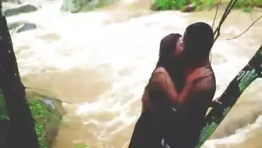 A horny couple fucks near a waterfall on a rainy day